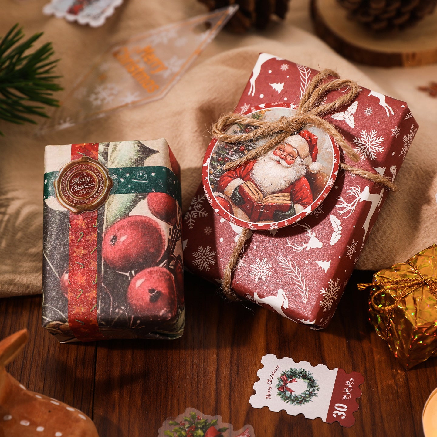 Two Christmas-themed gift boxes on a wooden surface with decorative elements.