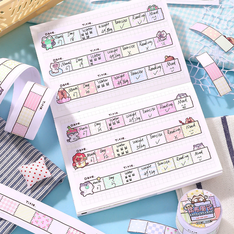 Sheet of planner stickers with cute character designs on a blue surface with additional stickers and a small container.