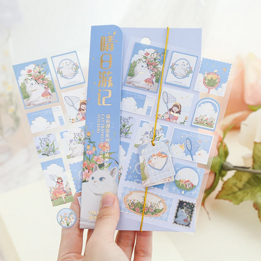 Pack of cat stickers with cute illustrations held by a hand against a blurred background
