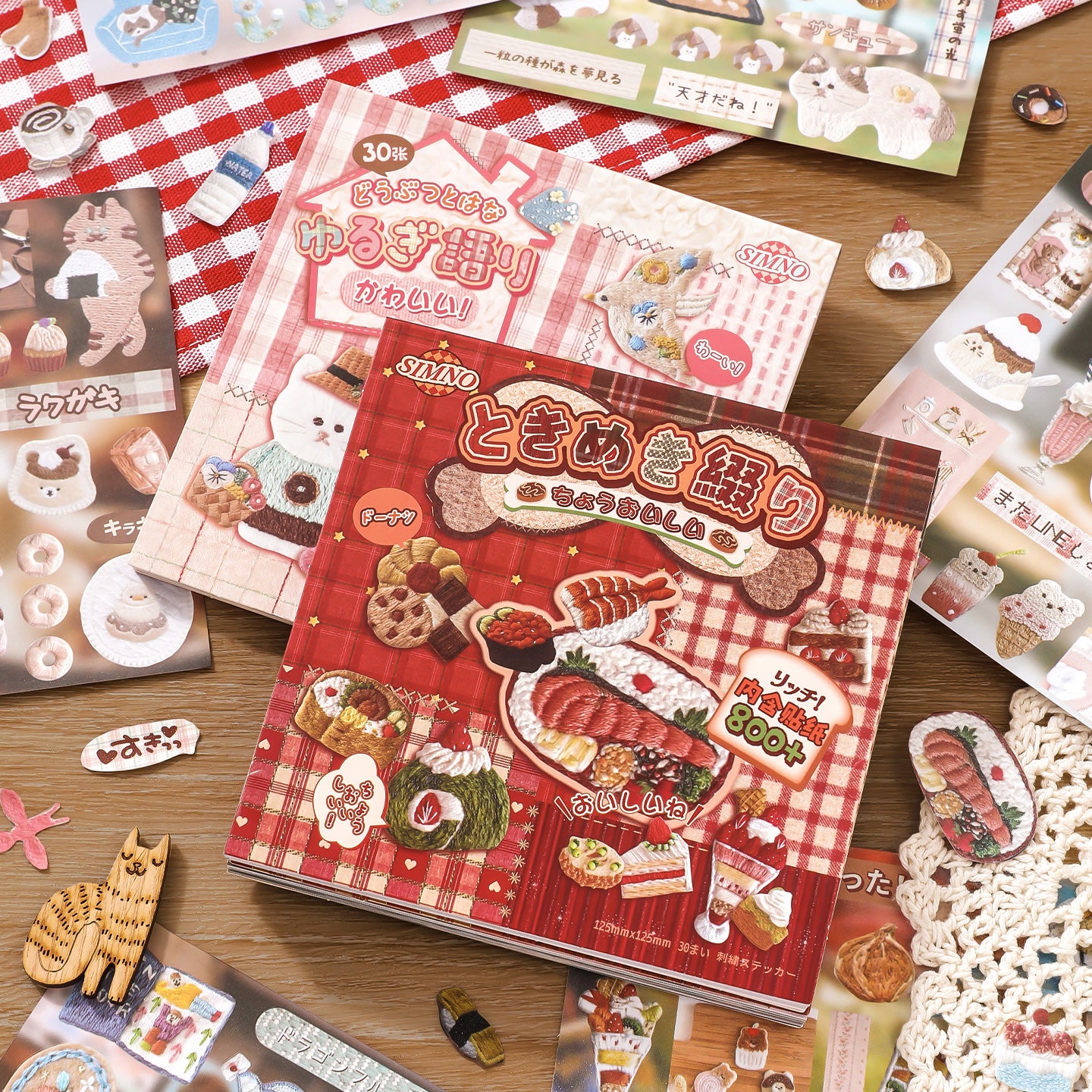 Collection of sticker books and  stickers on a wooden surface.