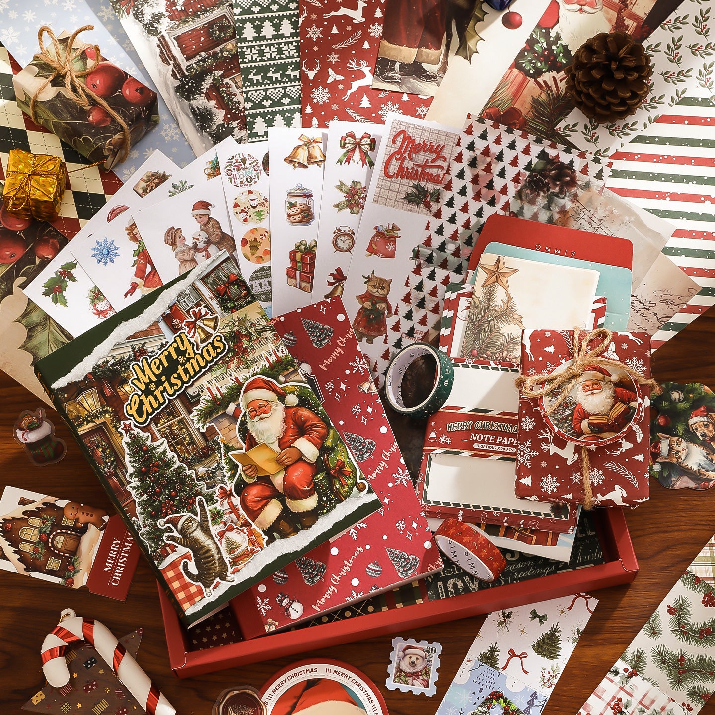 Collection of Christmas-themed stationery items including cards, envelopes, and a box on a wooden surface.