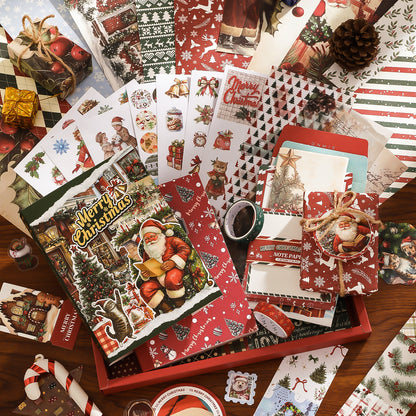 Collection of Christmas-themed stationery items including cards, envelopes, and a box on a wooden surface.