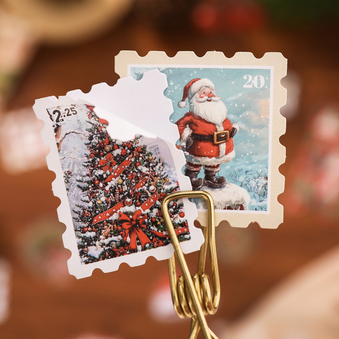 Gold paper clip holding a Christmas-themed stamp with Santa Claus and a tree.