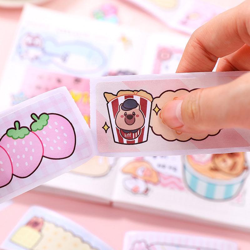 Hand holding a small package with cartoon character design on a pink background