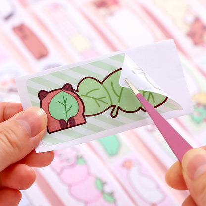 Hand holding a small card with a cartoon capybara design against a blurred background