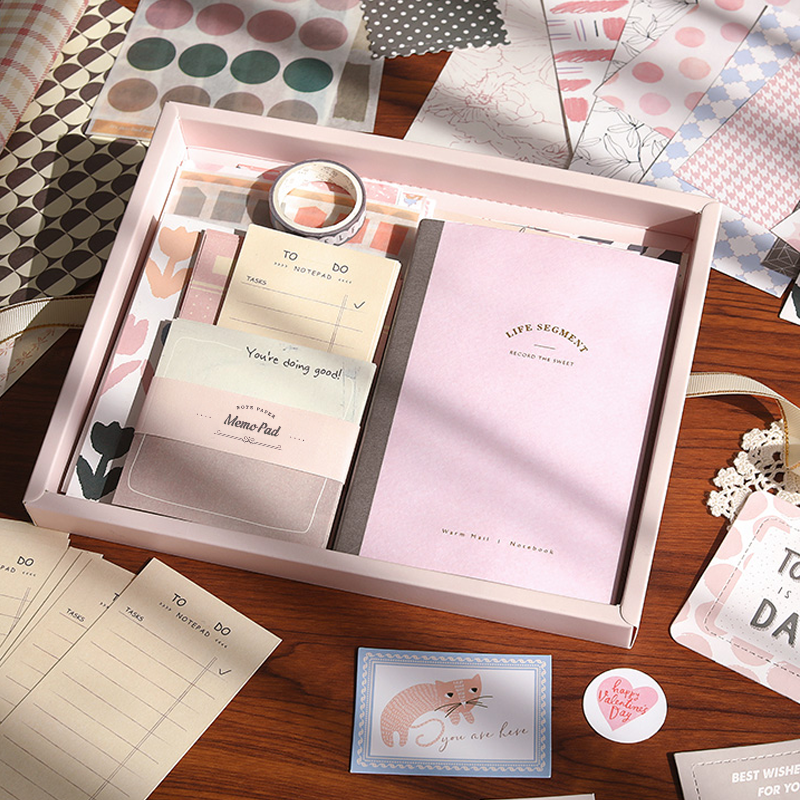 Stationery set with notebook, stickers, and cards on a wooden surface